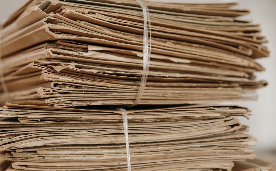 Dos montones de expedientes de papel atados con cuerda.