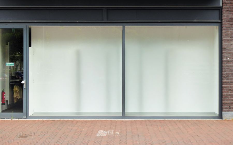 Escaparate de un local comercial vacío, con los cristales tapados desde dentro.