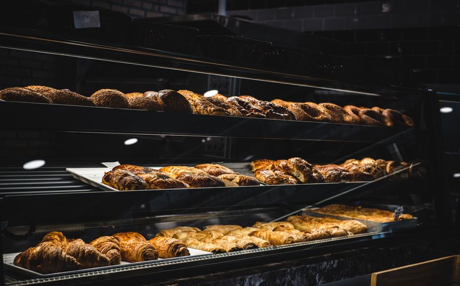 Vitrina de panadería con las bandejas de bollería y el pan del día.